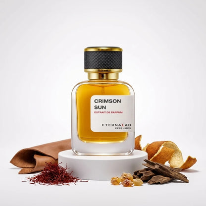 Eterna Lab Crimson Sun perfume bottle surrounded by leather, saffron, frankincense, oud, and dried orange peel.
