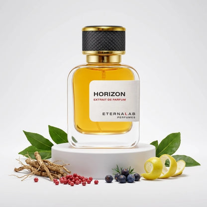 Eterna Lab Horizon Extrait de Parfum bottle surrounded by green leaves, dried roots, pink peppercorns, juniper berries, an...